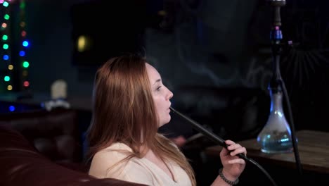 woman smoking hookah in a night club