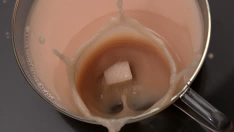 sugar cube falling into cup of tea