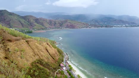 aerial drone of dry season landscape, beautiful blue ocean and rolling waves on remote tropical island, dili, timor leste