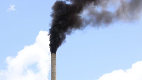 continuous black smoke billowing from tall smokestack