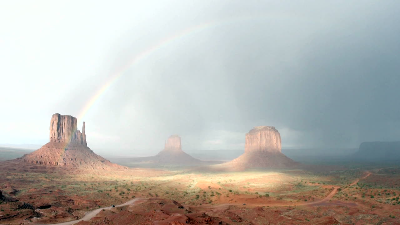모뉴먼트 밸리 유타에 폭풍이 몰아친 후 햇빛에 무지개가 사라집니다.