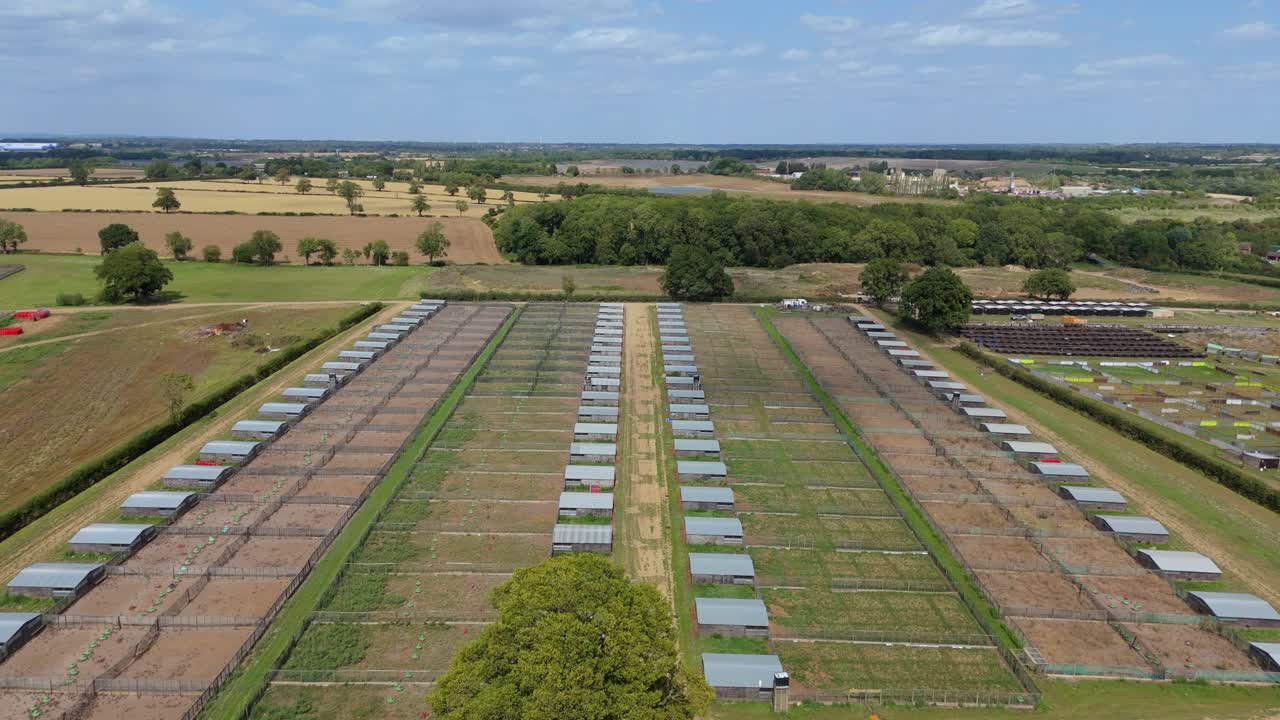 Aerial drone view of symmetrical farm buildings with hen houses and pig pens in rural Rugby England UK countryside