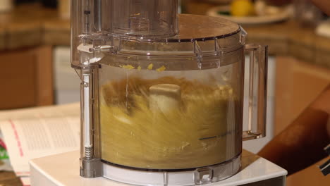 closeup, blending cashew nuts in food processor, focus on foreground