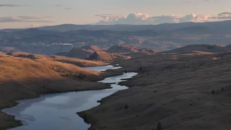 nature's beauty unveiled: aerial sunset view of grassland, lake, and majestic hills