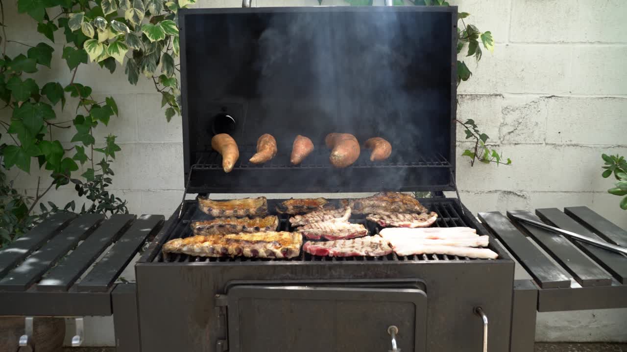 Tilberedning af lækre spareribs med søde kartofler på grill i baghaven.