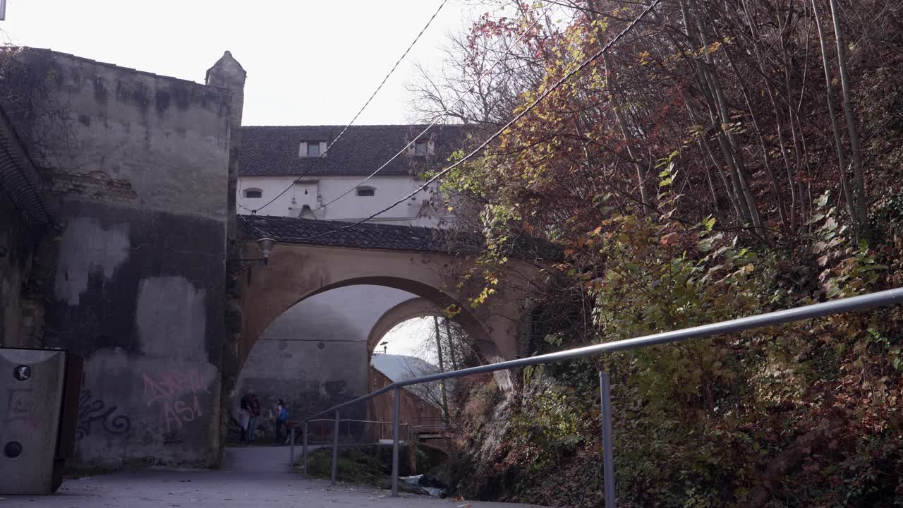 Walking through a historic stone archway in a European castle town