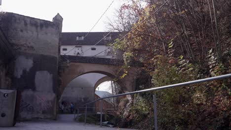 walking through a historic stone archway in a european castle town