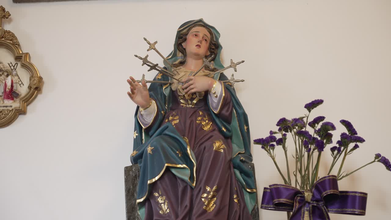 Primo piano di una statua religiosa della Vergine Maria trafitta da sette spade dolorose.