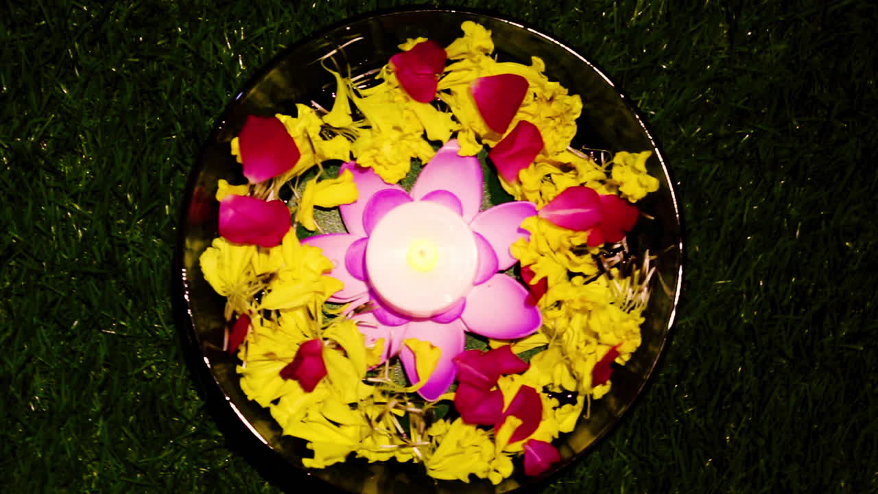 Colorful candle bowl decorated with flowers and petals for Diwali, prayer, or celebration. Perfect for festival, spiritual, and home decor visuals