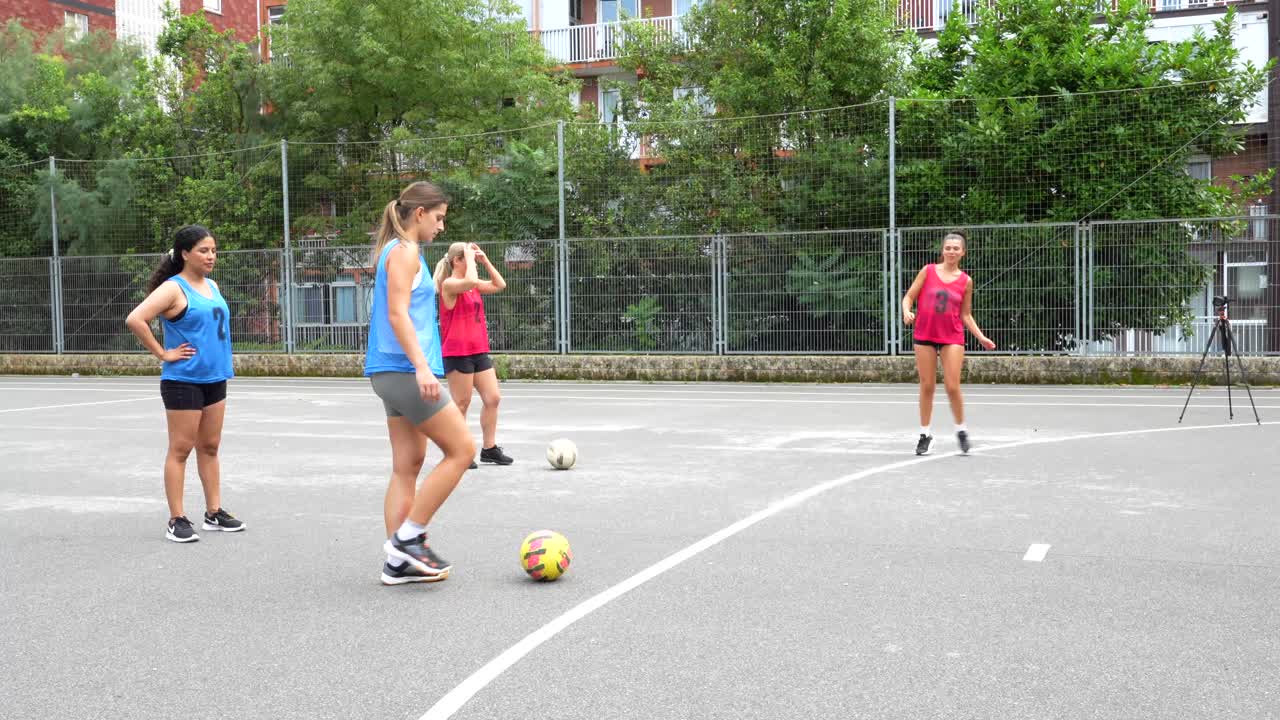 Women playing soccer on an urban soccer field