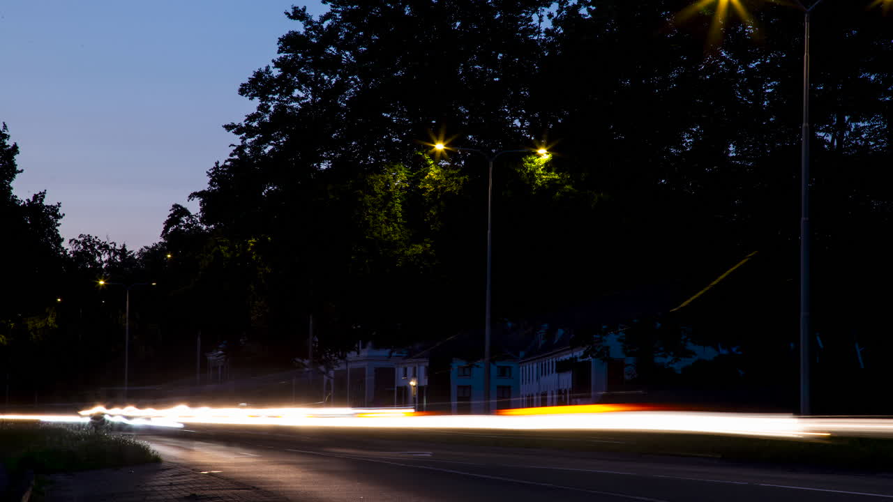 카메라 앞에서  ⁇ 박이는 빠른 운전 차의 헤드라이트의 아름다운 시간 경과 - 확대