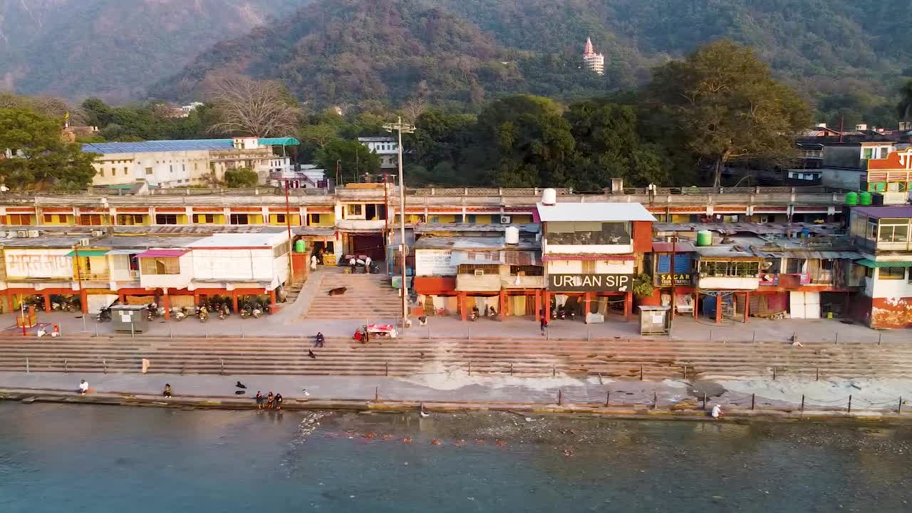 la orilla del río sagrado ganges llena de templos religiosos al atardecer se toma un video aéreo en rishikesh uttrakhand india el 15 de marzo de 2022
