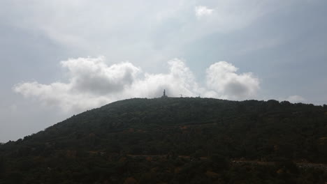 mountaintop with statue and cloudy sky
