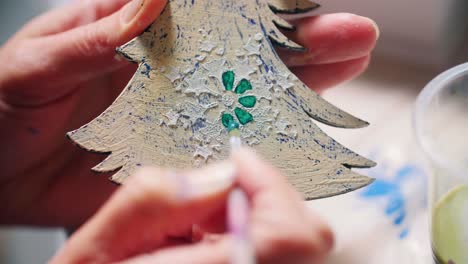 hand painting a christmas tree ornament