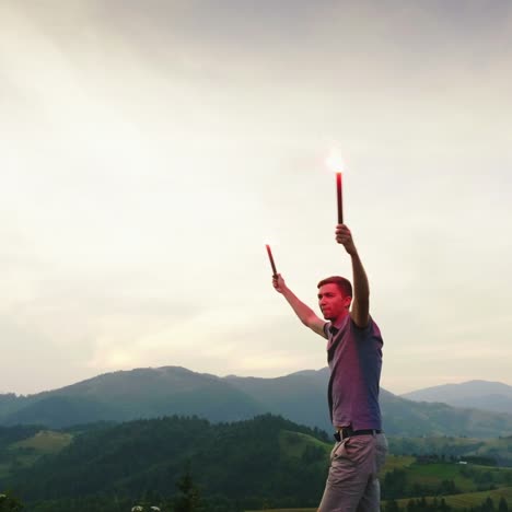 a man in the mountains signals with hand fireworks looks up 1