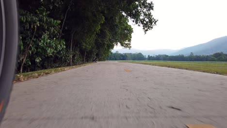 Cabalgando-Por-Un-Camino-De-Cemento-Con-Montañas-En-La-Distancia