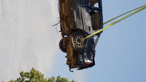 Zerstörtes-Auto-Wird-Mit-Kran-Zum-Recycling-In-Die-Luft-Gehoben,-Vertikales-Video