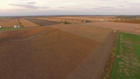 Patterns-and-colors-of-flat,-wide-open-farms-in-the-heartland-at-sunset