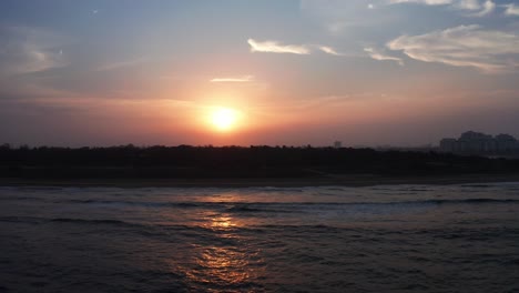 peaceful drone aerial footage of a beach ocean water during sunset