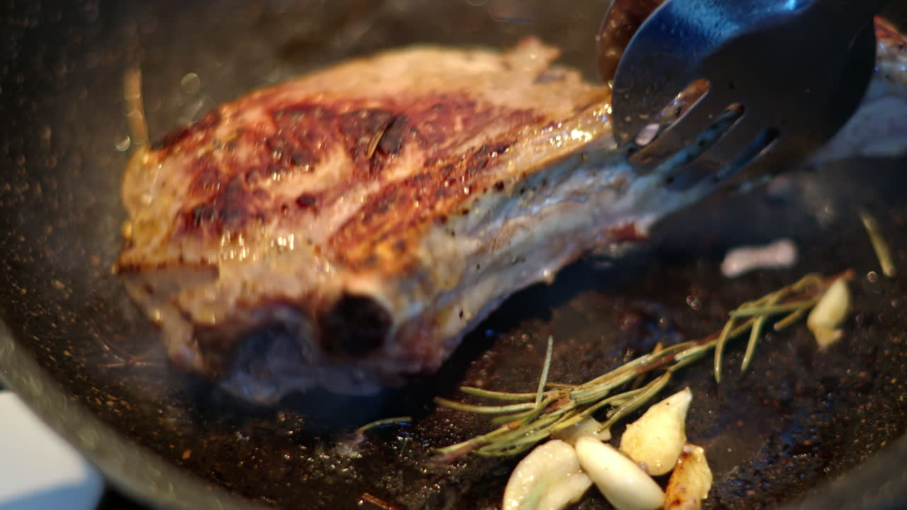 Juicy ribeye steak meat beef being prepared with rosemary and garlic