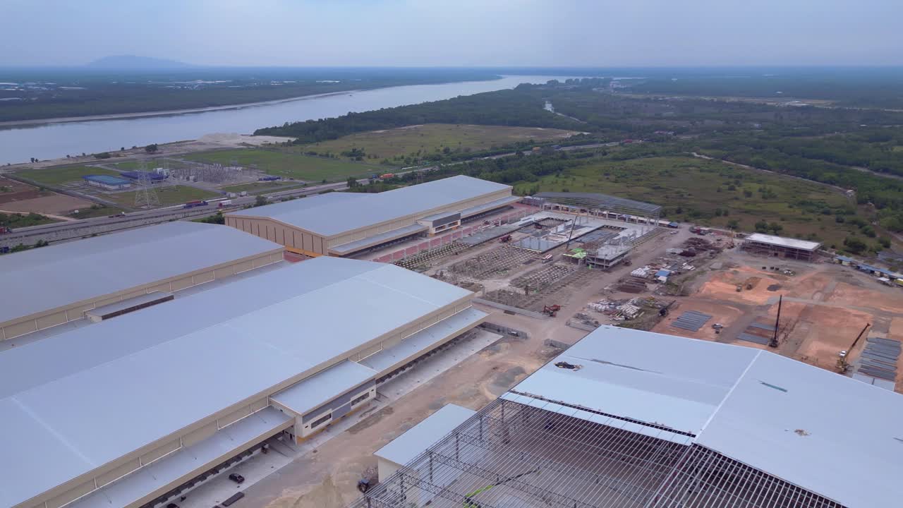 Grande parco industriale con magazzini, camion e container vicino a Port Klang. Splendida vista aerea panoramica con rotazione a destra da drone