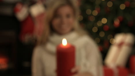una rubia bonita mostrando una vela