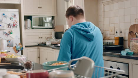 un adolescente feliz con síndrome de down bailando en la cocina divirtiéndose celebrando un baile divertido disfrutando del fin de semana en casa