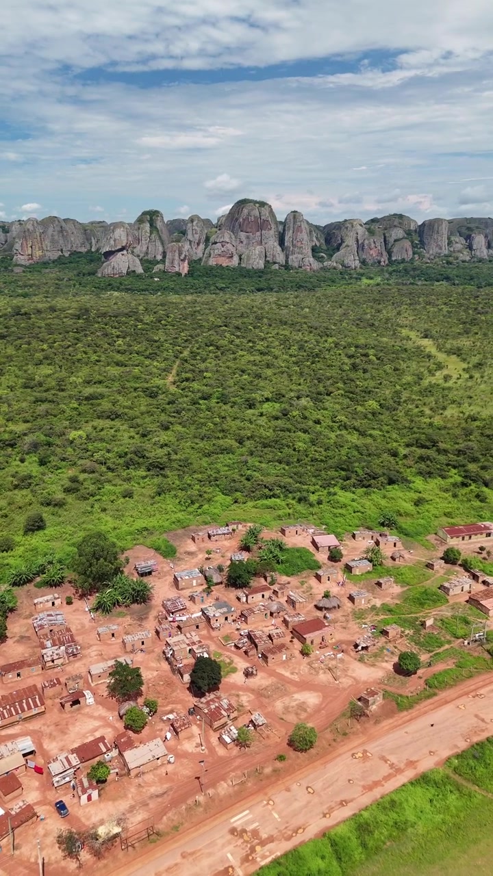 Splendida ripresa aerea dei famosi monoliti giganti delle Rocce Nere di Pungo Andongo con un escursionista in piedi su un punto panoramico elevato contro un cielo azzurro nella provincia di Malanje, Angola