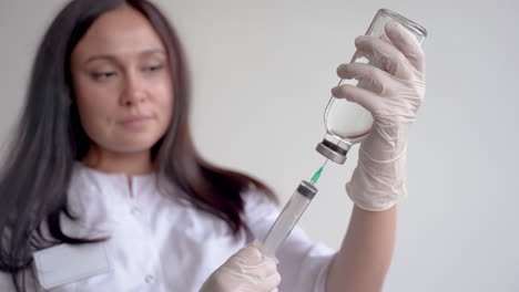 close up of a female doctor filling a syringe with a vaccine