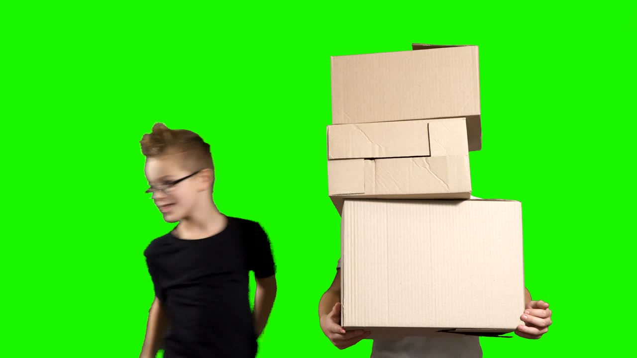 el niño pone las cajas una por una en las manos de su hermano.