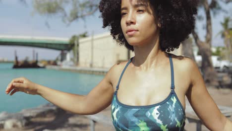 Confident-black-girl-stretching-hands-in-sunlight