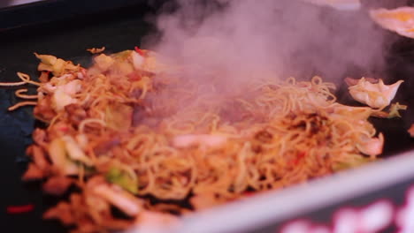 vendor frying a common japanese street food, yakisoba