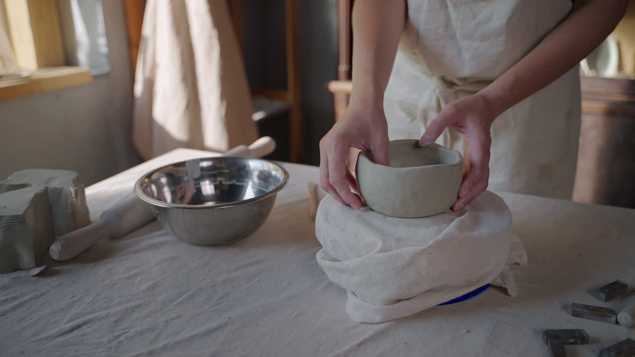 mujer creando un cuenco de arcilla