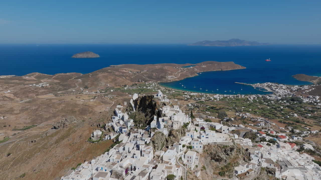 White chapel sits alone atop cliff of Serifos Chora, Aegean Sea establishing behind in morning sun