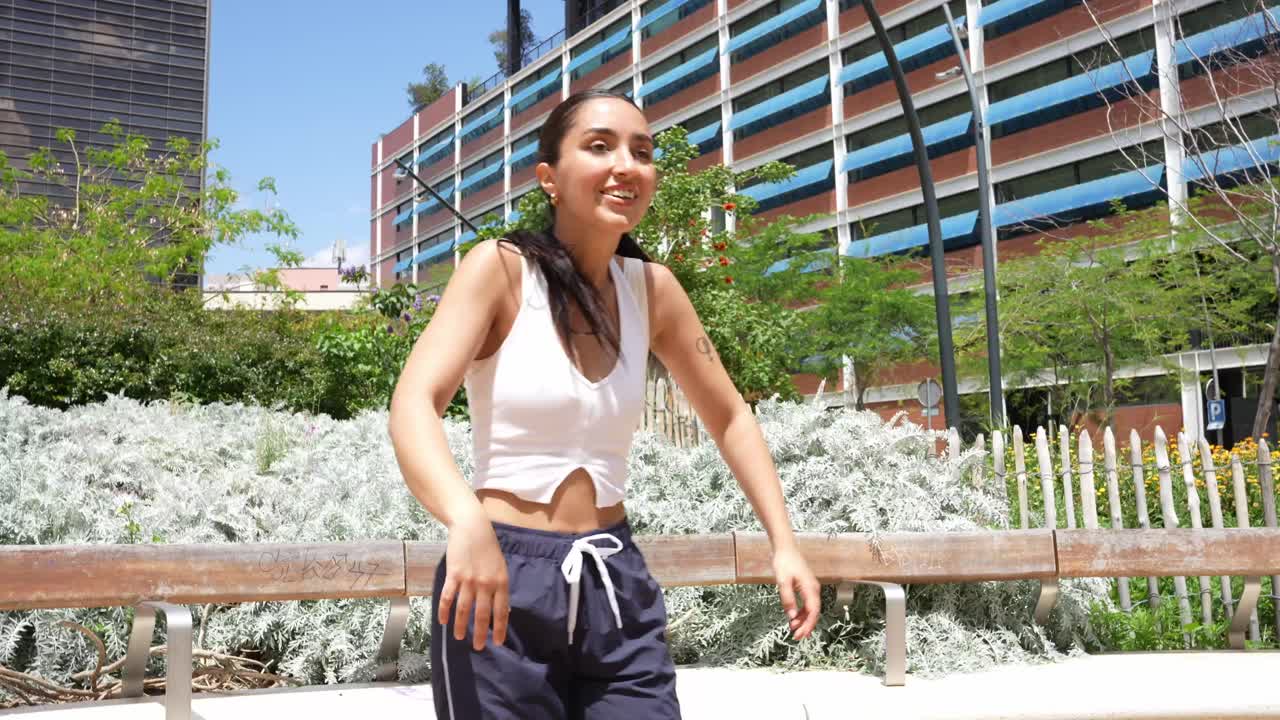 Woman dancing in an urban park on a sunny day