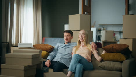 family enjoy moving new home sitting at couch. couple rejoicing relocation.