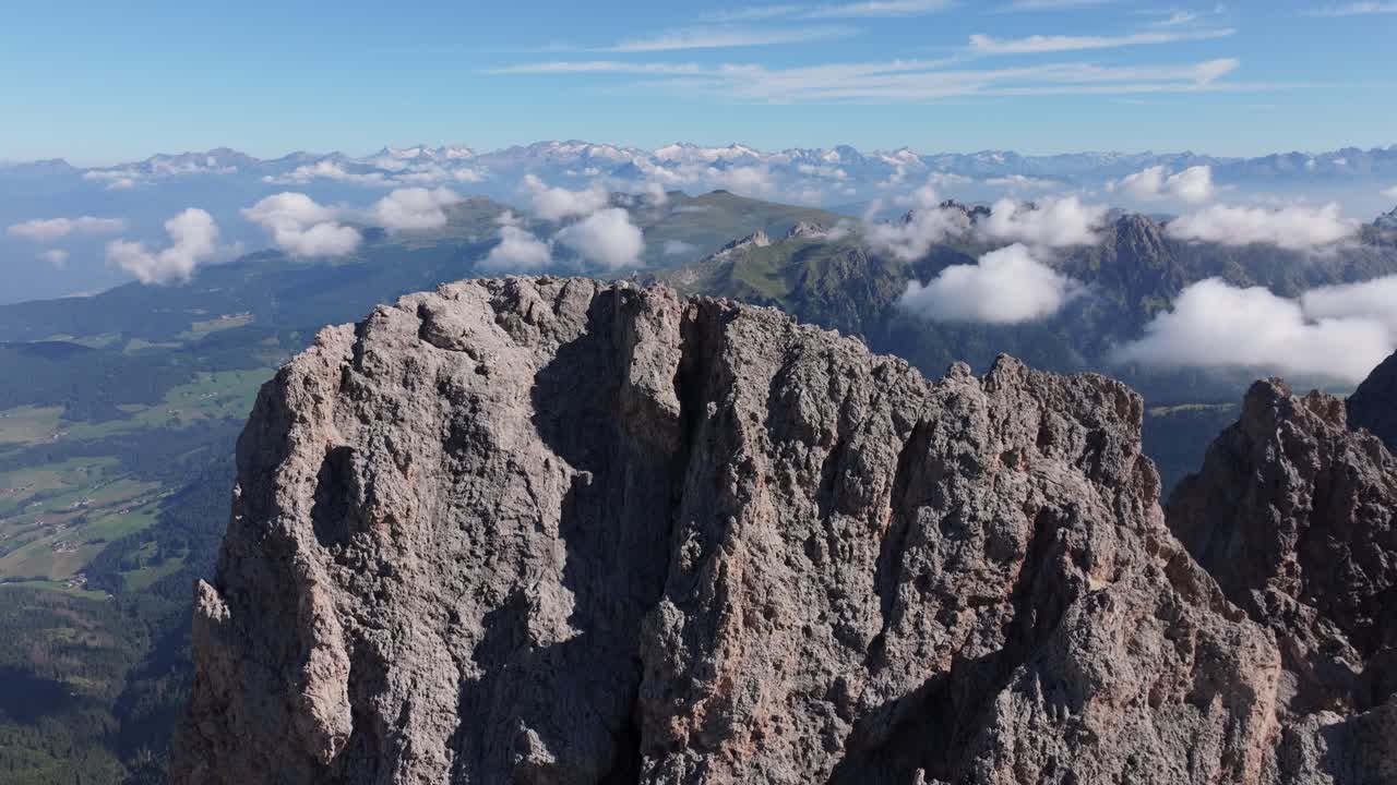 Clear summer sky over Seceda’s rocky peaks, with clouds rolling below the cliffs