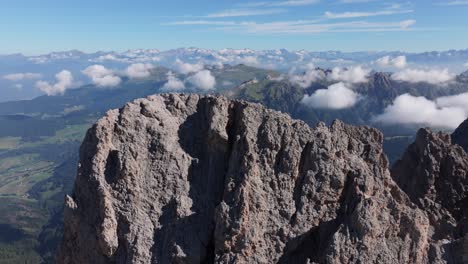 clear summer sky over seceda’s rocky peaks, with clouds rolling below the cliffs