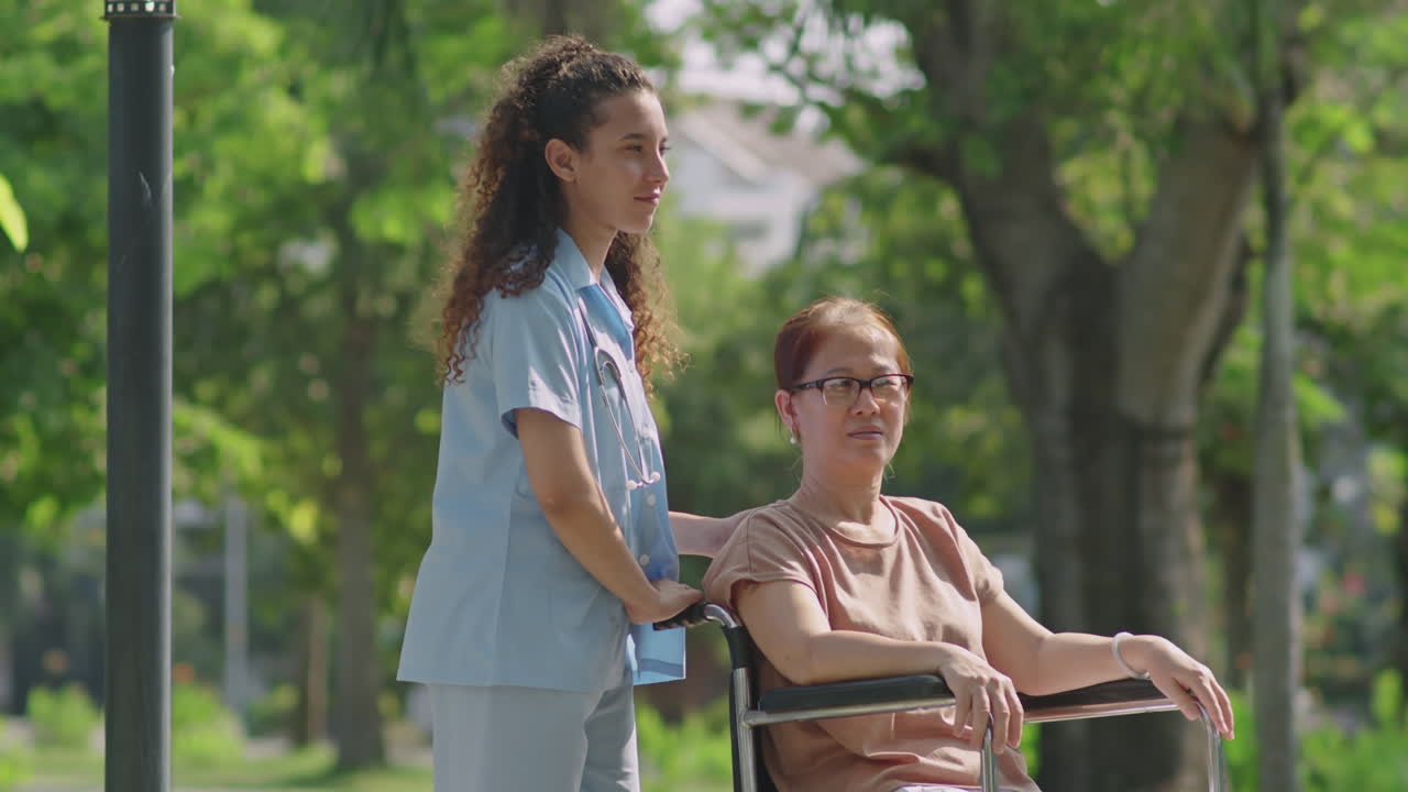 Nurse assisting elderly woman in wheelchair