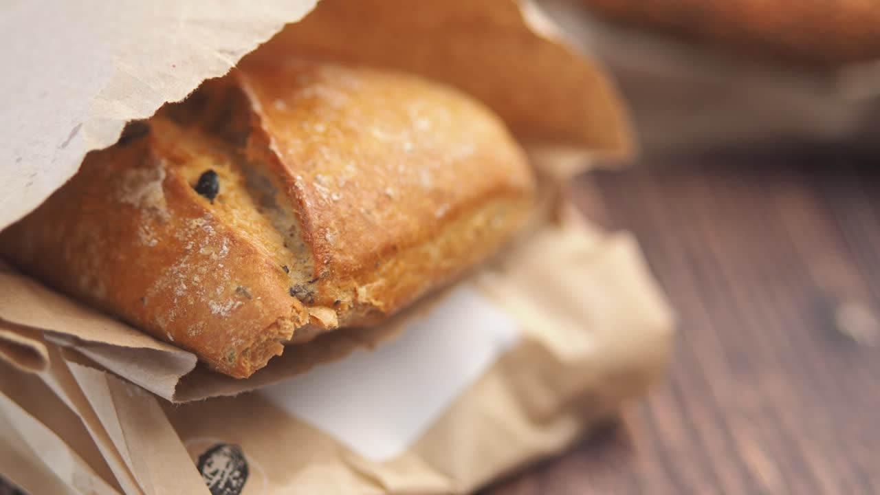 Close-up of a loaf of artisan bread in a brown paper bag