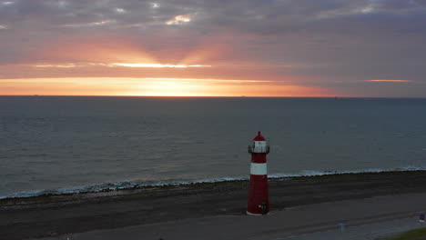 The lighthouse of Westkapelle during a bright orange sunset, with a lot of wind