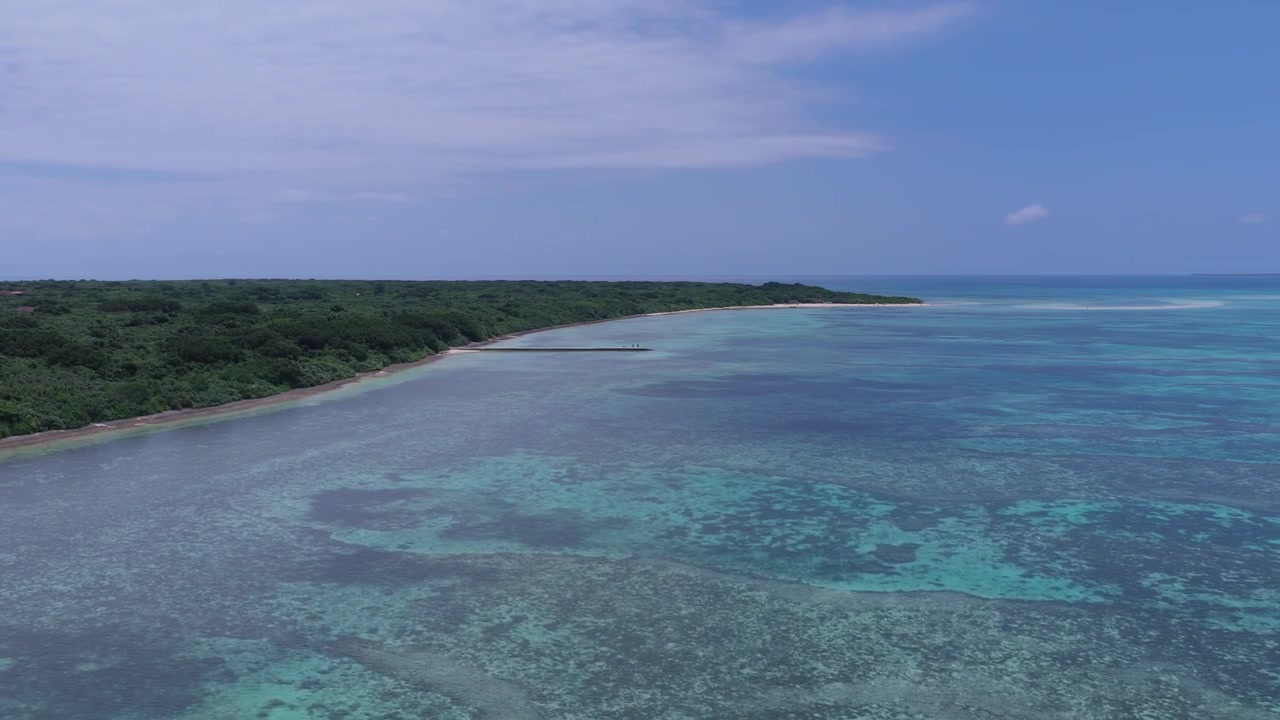 Riprese aeree orizzontali che si muovono a destra sopra la costa e le acque turchesi poco profonde del Molo Nishi e della Spiaggia Kondoi, Isola di Taketomi, Okinawa, Giappone.