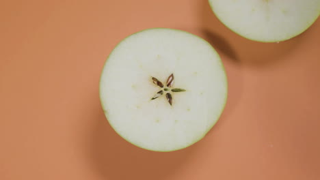 top view shot of small green apple on isolated orange surface