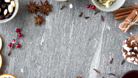 Ingredientes-Y-Especias-Para-Hacer-Vino-Caliente-Con-Especias.-Concepto-De-Bebidas-Navideñas-Y-De-Temporada:-Nieve-Cayendo-Sobre-Fondo-Gris.-Ingredientes-Y-Especias-Para-Hacer-Vino-Caliente-Con-Especias.-Concepto-De-Bebidas-Navideñas-Y-De-Temporada:-Nieve-Cayendo-Sobre-Fondo-Gris.