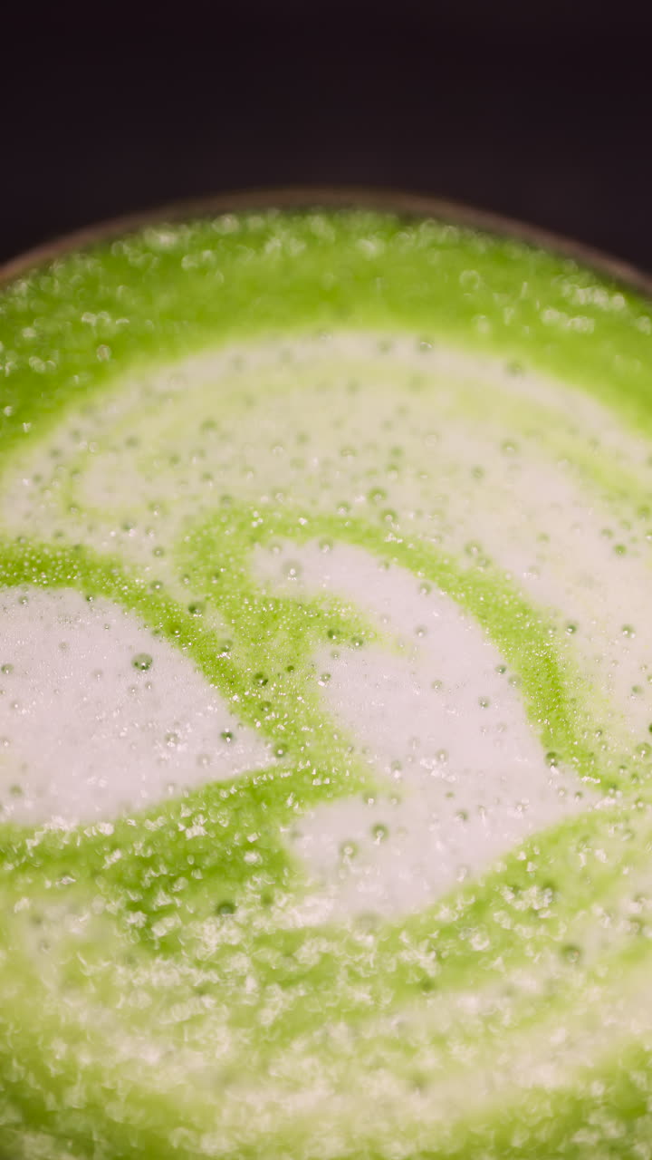 Close up of a matcha latte on a tray at a cafe. Vertical