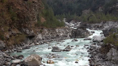 a river filled with glacier water in the mountains of the himalaya mountain range