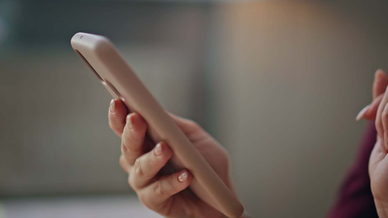 Primo piano di una ragazza che scorre lo schermo del cellulare. La ragazza sta facendo un ordine di acquisto da casa.