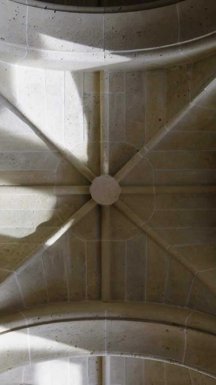 Video verticale: Telecamera che si inclina mostrando una volta a crociera in pietra all'interno di una chiesa, evidenziando il concio centrale.