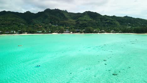 Aerial-drone-shot-of-couple-kayaking-in-Muri-Lagoon,-Rarotonga-Cook-Islands