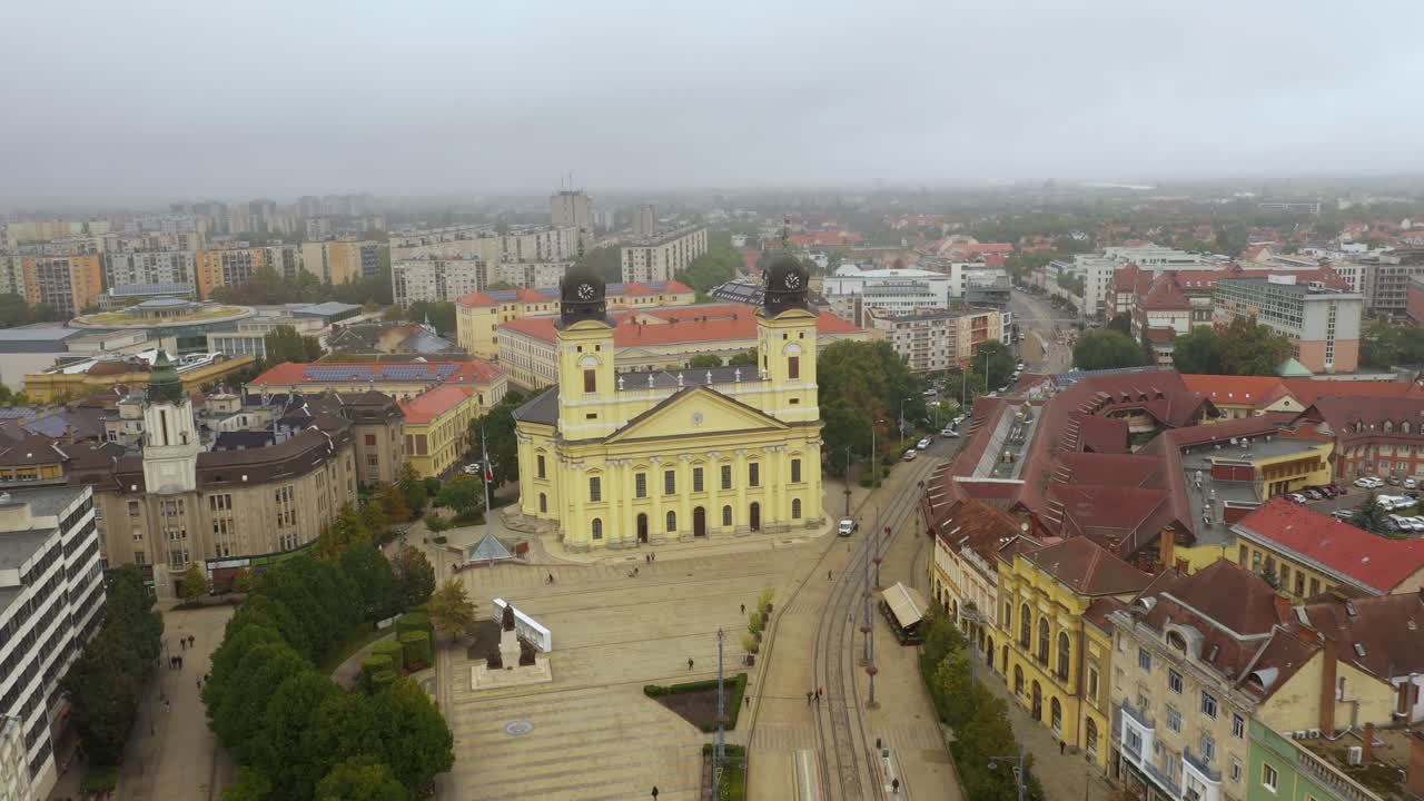 imágenes de drones de la iglesia en la plaza principal de la ciudad de debrecen en clima lluvioso drone de otoño vuela rápido hacia atrás